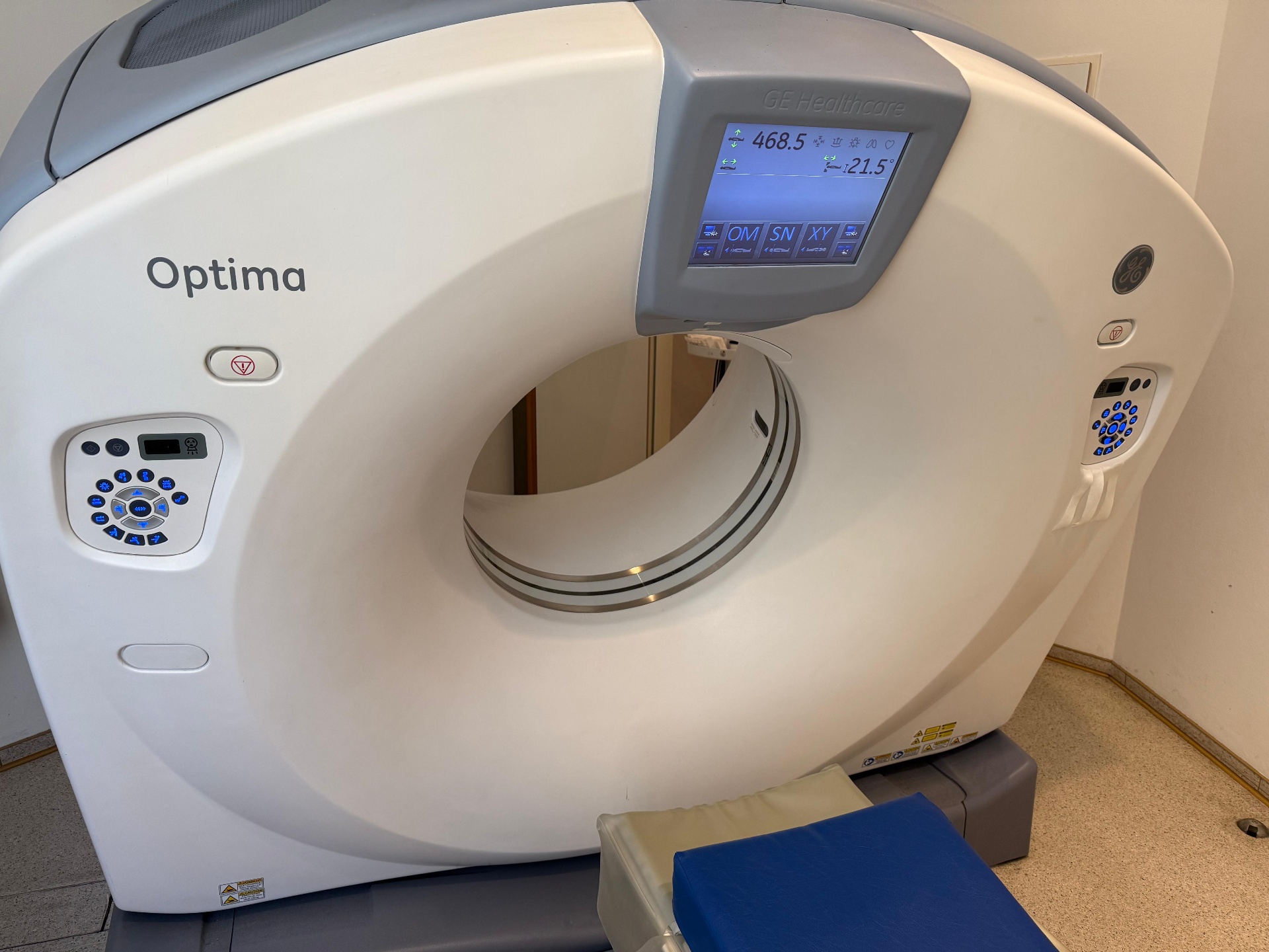 GE Optima CT520 gantry with GE Healthcare display showing table position 468.5 mm and tilt 21.5°