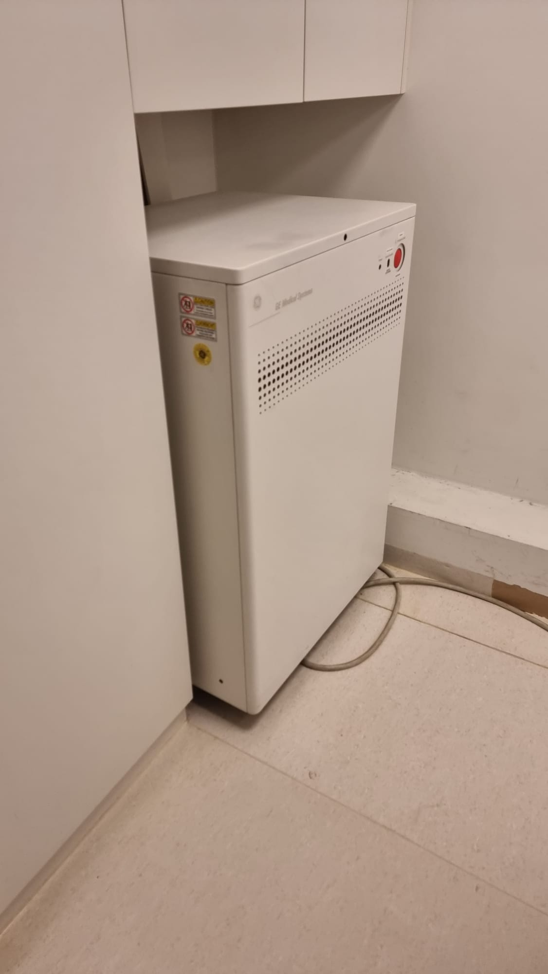 GE Medical Systems Power Distribution Unit (PDU) cabinet included with this GE Optima CT660 128-slice CT scanner, photographed in scan-room corner with emergency-off circuit intact by MTC in Miami, Florida