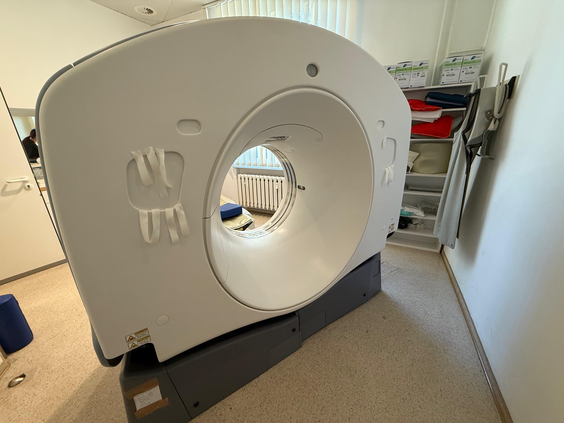 GE Optima CT520 rear gantry view showing patient straps and 70 cm bore from the table side