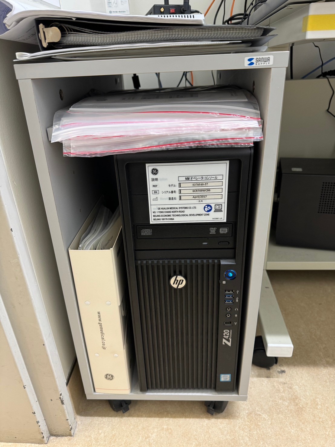 GE Discovery 630 NM/CT operator console — HP Z420 workstation with GE Healthcare service binder