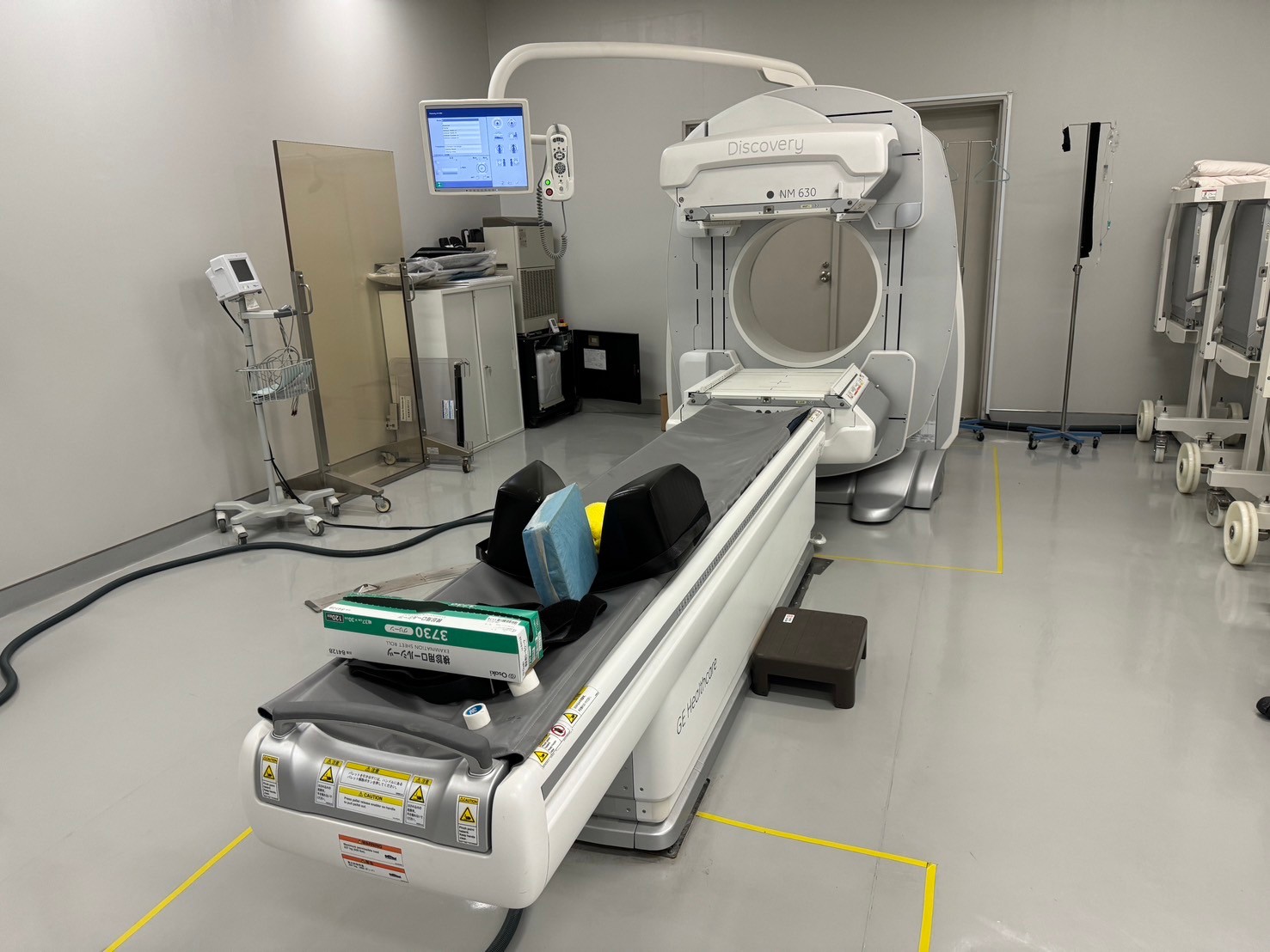 Refurbished GE Discovery 630 SPECT CT installed in clinical room with patient table and operator panel
