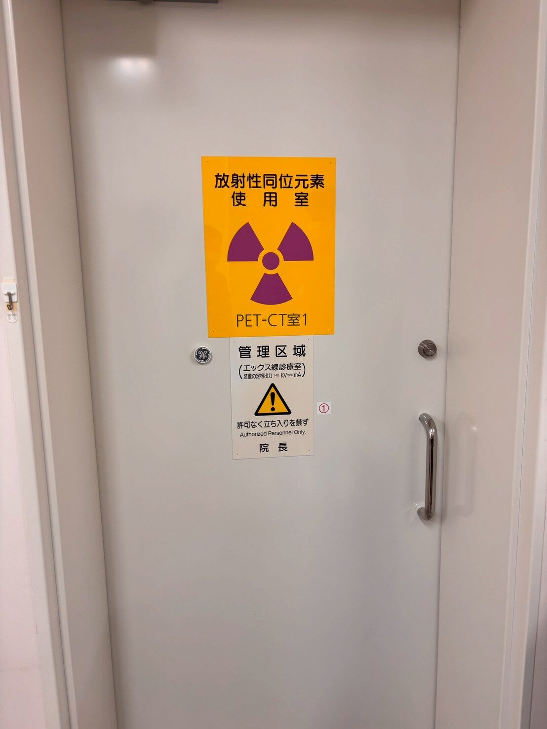 GE Discovery 710 PET-CT scanner room entrance with radiation controlled-area signage in Japan